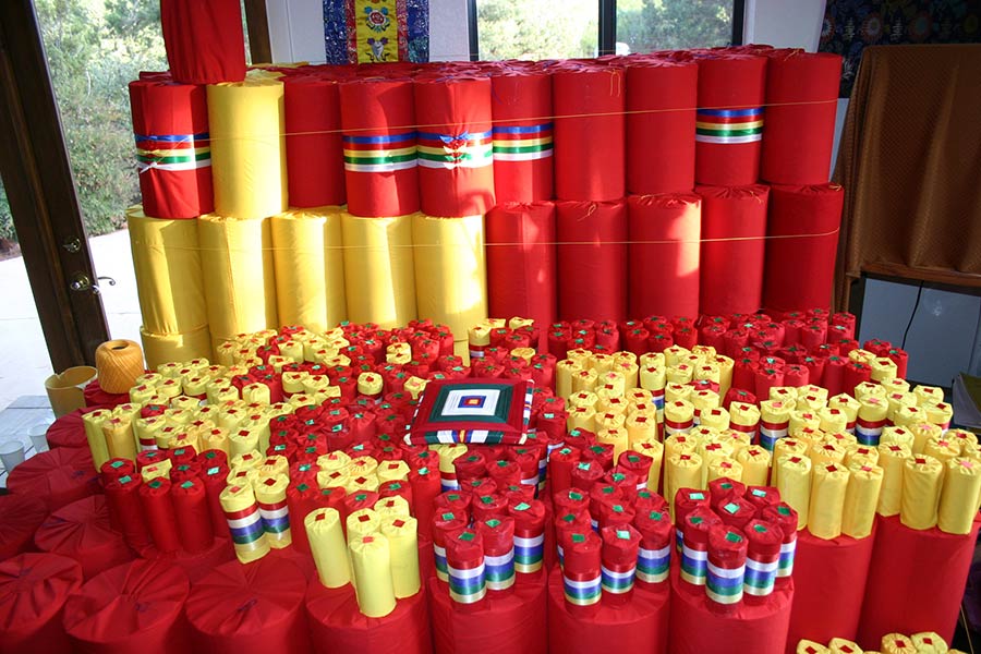 Mantras (prayers) of various Deities, coated in saffron and wrapped in cloth and ribbon. They will go inside the Stupa.