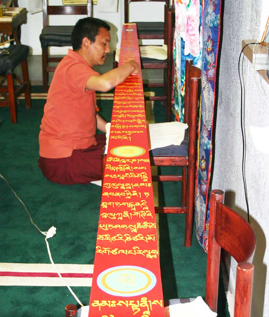 Lama Gyurme Rabgye painting mantra on the sok-shing (tree of life) that forms the spine of a stupa. Later, relics and offerings will be tied on and it will be covered in colored cloth.