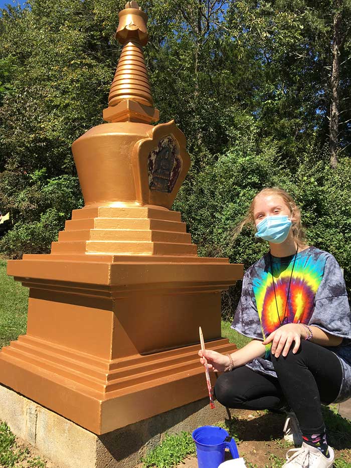 Volunteer helps paint and upkeep a stupa at KPC in Maryland