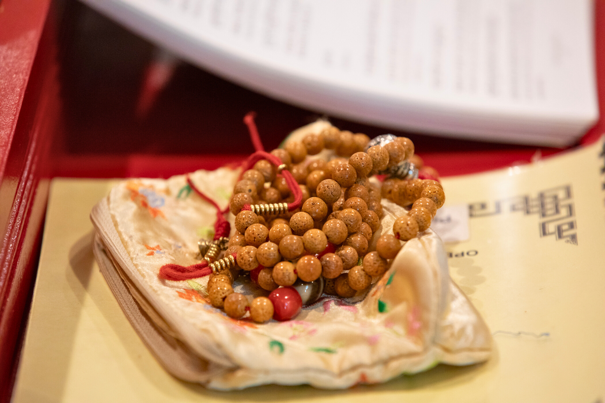 mala on top of silk mala bag and prayer book on prayer bench
