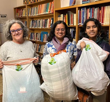 KPC Buddhist Relief volunteers holding bags of donated clothing